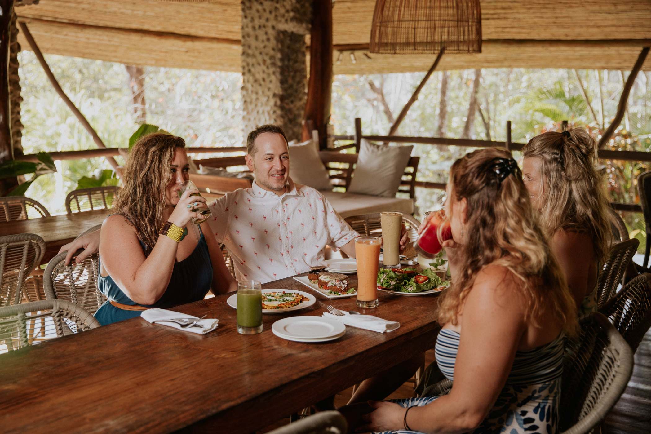 Guests sharing a fresh, colorful meal at the open-air palapa table at Hacienda del Sol, Guanacaste, Costa Rica